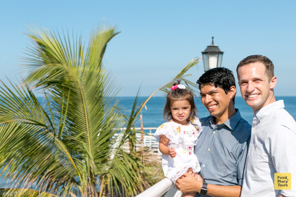 Gay Couple and their toddler daughter with an LGBT Family Photographer in Puerto Vallarta on a photo shoot on the Boarwalk aka El Malecon de Puerto Vallarta + Vallarta Pride