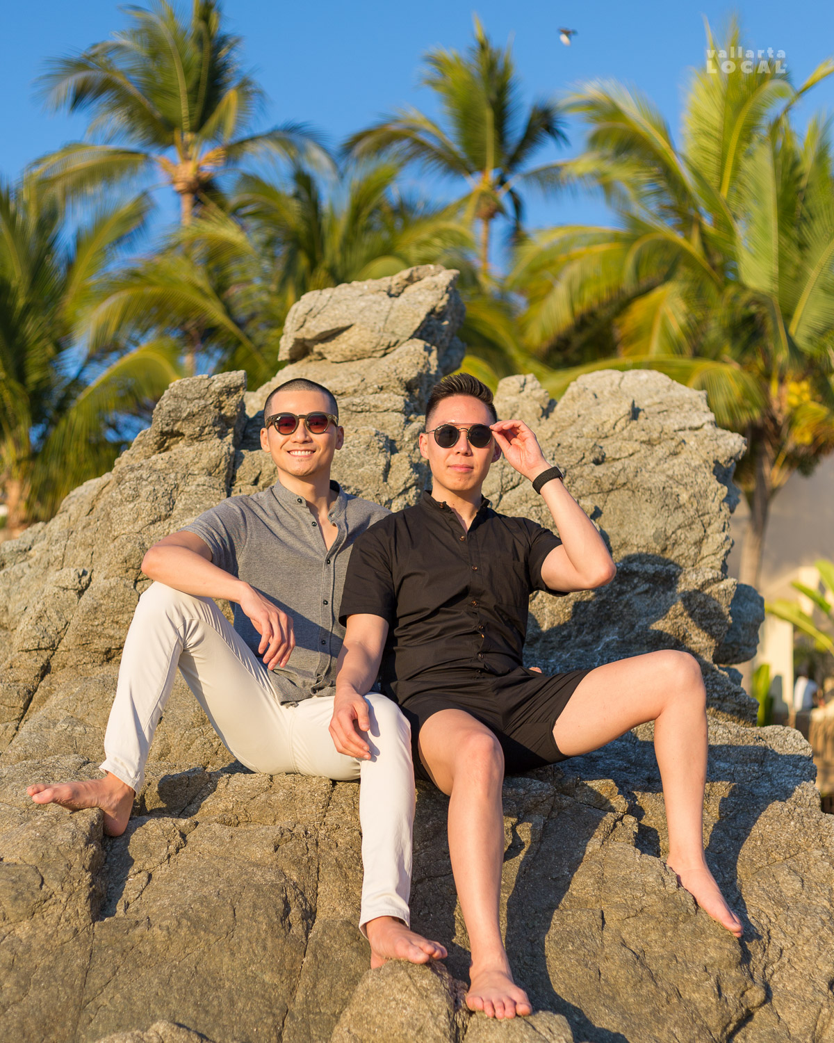 Gay couple posing on a rock for a beach photo shoot in Puerto Vallarta